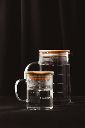 Jugs of water reflection dark backgroundの写真素材