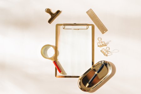 Flat lay of gold stationery on light backgroundの写真素材