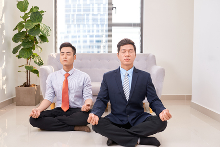 business people doing yoga in officeの写真素材