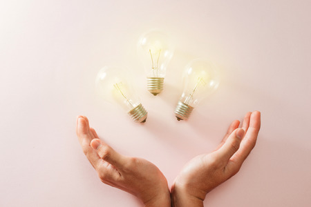 green world in the heart hand with light bulb - pink backgroundの写真素材