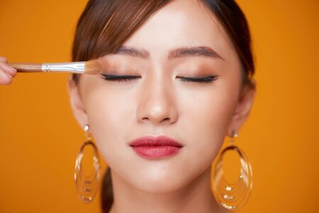 makeup artist deals makeup brush for eyes. makeup for a young beautiful girlの写真素材