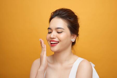 Surprised model woman isolated on yellow background. Laughing girl with red lips.の写真素材