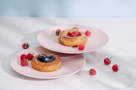 Tasty fresh homemade puff pastry with berries on the white wooden table