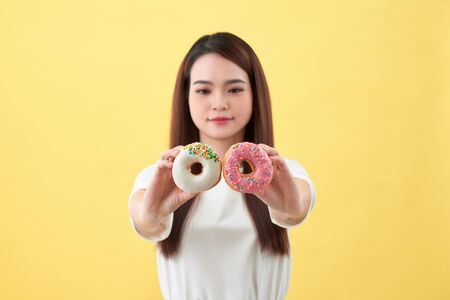 Beauty fashion model girl taking sweets and colorful donutsの写真素材