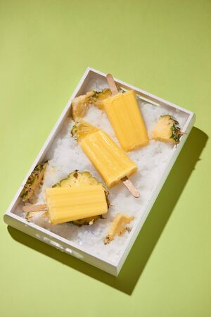 Yellow fruit popsicles on a tray top view, summer moodの写真素材