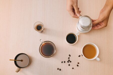 Cups of coffee with coffee beans and vietnamese Phin filter on wooden backgroundの写真素材