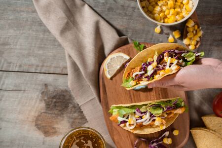 Traditional mexican taco with chicken and vegetables on wooden table. Latin american food.の写真素材