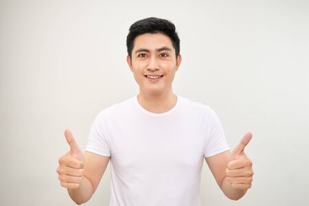 young asian man showing two thumbs up signの写真素材