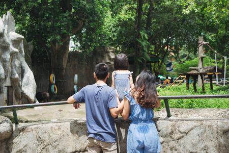 Happy family at the Zoo looking at a Bearの写真素材