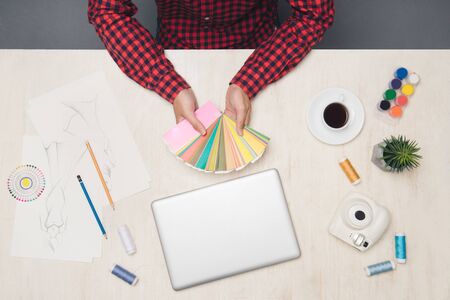 Top view of male fashion designer is showing or finding color at his office table.の写真素材
