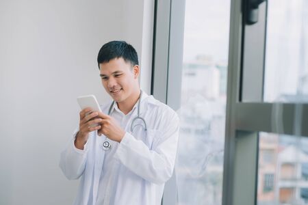 happy young doctor holding cell phoneの写真素材