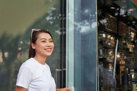 Shopping woman happy and looking away at copy space outdoors.の写真素材