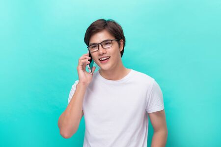 Young asian handsome businessman smilling and using his smartphone. Portrait of asian business man happy and using smart phoneの写真素材