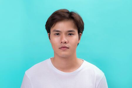 Young casual asian man portrait isolated on blue backgroundの写真素材