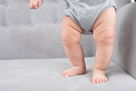 Mother training her infant baby to walk first stepsの写真素材