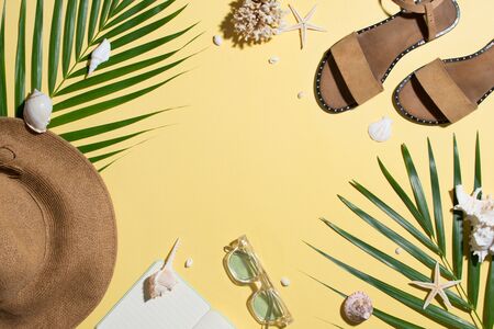Leather sandals, tropical palm leaves, seashells, starfish on white background. Summer backdrop.の写真素材