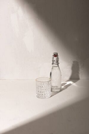 Glass bottle of water with drinking glass