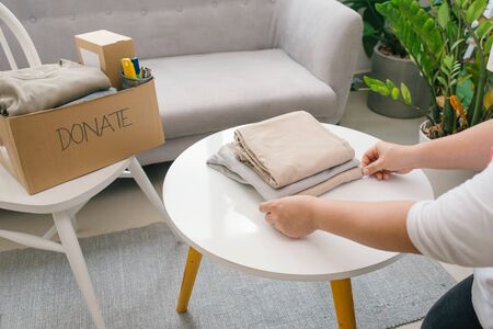 Woman preparing the old clothes she wants to donate for charity.の写真素材