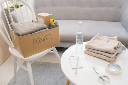 Donation box and casual clothes in livingroomの写真素材