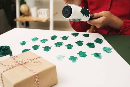 Woman decorating present paper cover on Christmas. Xmas, noel concept.の写真素材