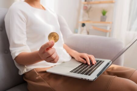 Online payment, Woman hands holding a Bitcoin and using smart phone laptop for online shopping crypto currencyの写真素材