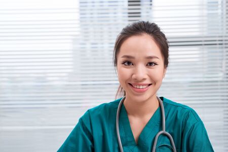 Female doctor smiling at camera, office interiorの写真素材