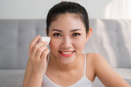 Potrait of young Asian woman using sponge blender make up tool on face. Make-up conceptの写真素材