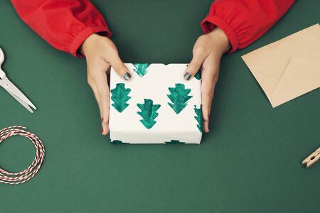 Close up of woman's hands wrapping Xmas paper. Christmas concept.