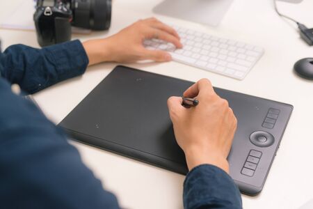 workplace of photographer. Creative designer hands working graphic tablet, photographic equipment on...