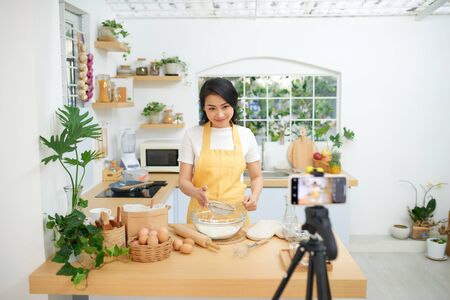 Young asian woman recording video for her blogの写真素材