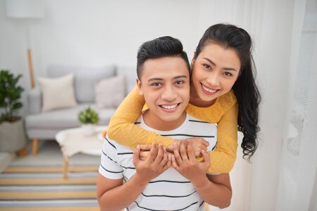 Asian couple piggyback ride indoorの写真素材