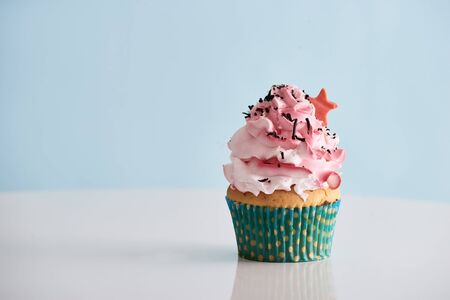 Cupcake with pink cream icing on tableの写真素材