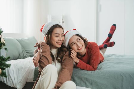 Asian girl best friends celebrating christmas togetherの写真素材