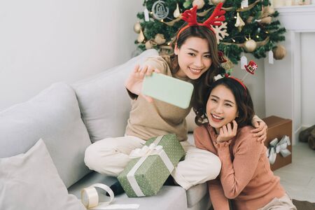 Christmas photograph. Asian friends taking selfieの写真素材