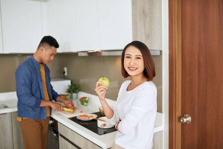 Photo of happy young couple preparing eat in the kitchen together. Family concept.の写真素材