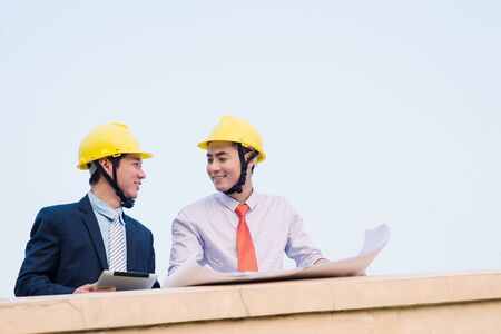 Asian engineer was acting with his secretary on the Business building background.の写真素材