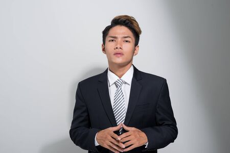 Portrait of young and handsome  Asian business man holding a jacket isolated on white backgroundの写真素材