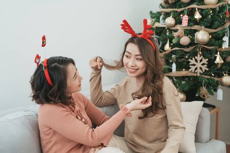 Asian Lesbian couple celebrate Christmas festival. LGBTQ female teen wear Christmas hatの写真素材