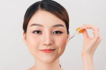 Photo of a beautiful young pretty asian woman with healthy skin take care of her skin with cosmetics.の写真素材