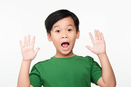 Portrait of joyful or surprised cute asian schoolboy with raised hands.の写真素材