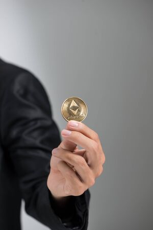 man's hand holding golden Bitcoin isolated on white backgroundの写真素材