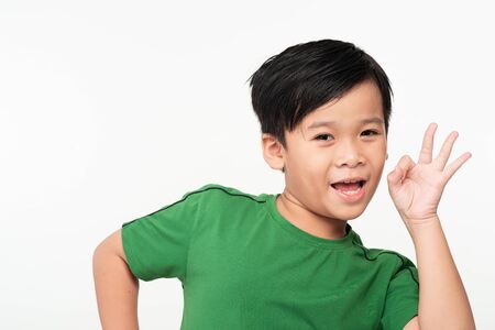 Little cute boy showing OK sign and smiling, isolated on white backgroundの写真素材