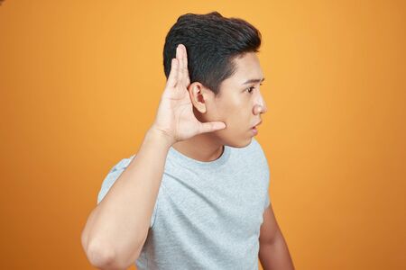 the Asian man raised his ears to the hearing with his hand