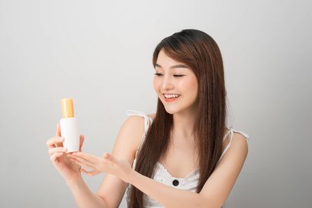 Asian woman showing cream on her hand, isolated on whiteの写真素材