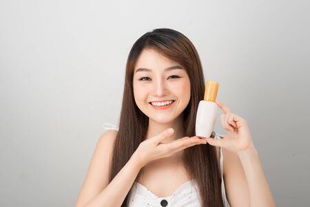 asian woman showing cream on her hand, isolated on whiteの写真素材