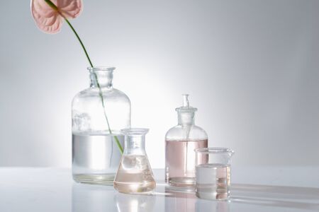 Beautiful composition with perfume samples and flowers on table
