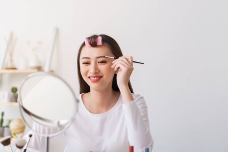 Attractive talented female blogger reviews beauty product for video blog, gives advice to girls and women, films process on camera.の写真素材