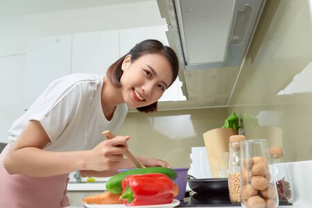 Young Woman Cooking in the kitchen. Healthy Food. Dieting Concept. Healthy Lifestyle. Cooking At Home. Prepare Foodの写真素材