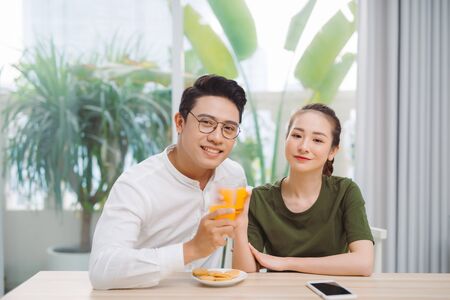 Happy young asian couple making organic drink together.の写真素材