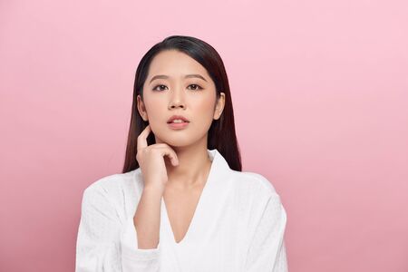 Portrait of beautiful woman with natural make up touching her faceの写真素材